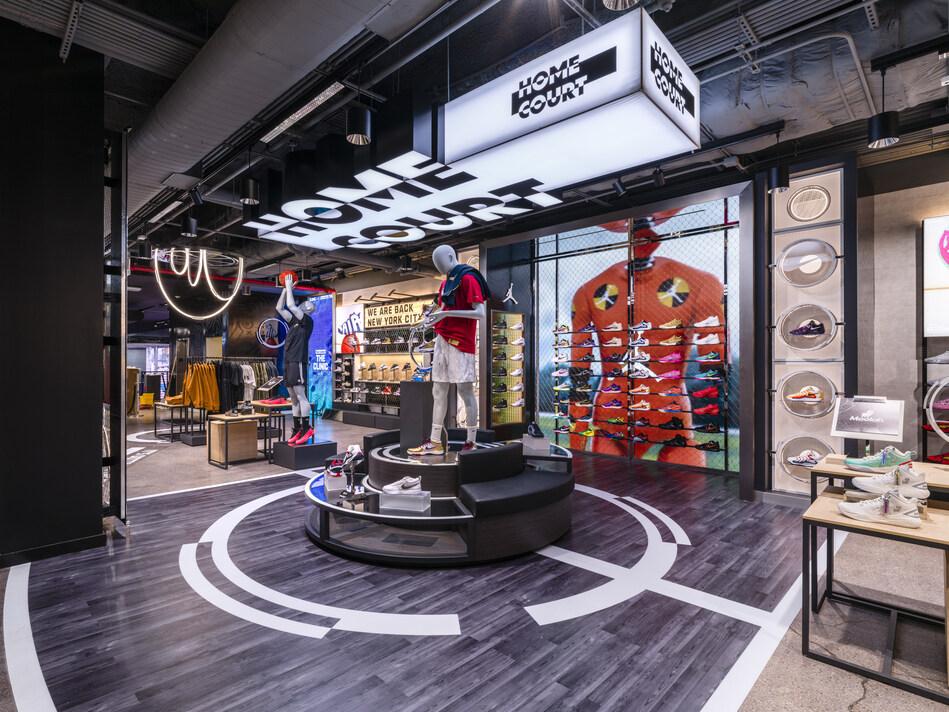 Interior of the Foot Locker Home Court basketball destination, with bold HOME COURT signage and court-line flooring.