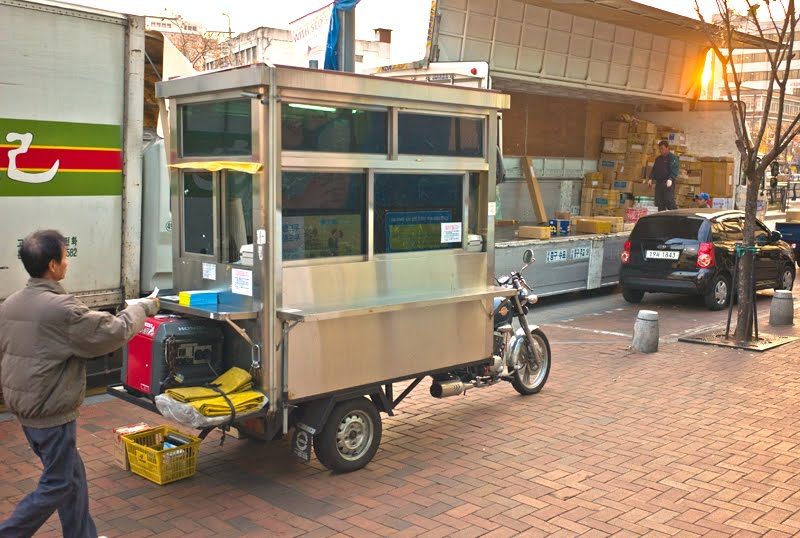 Not only does the office come to you, but so does the truck. Here, you can see the transaction taking place while the truck is being loaded in the background. This is just one small part of the ecosystem that supports the merchants and tradesmen in Seoul.