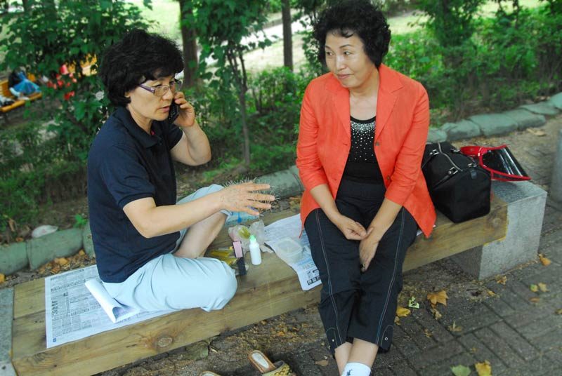 Oriental medicine is very well respected in Korea. On my way to the baseball game, I happened across these two women. At first, I just noticed two women sitting on a park bench, one chatting away on a cell phone; the other holding her hand.